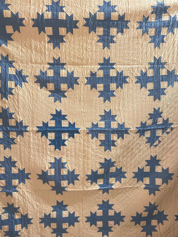 A Blue "Star Cross" Pattern Quilt On White Background (1 of 1)