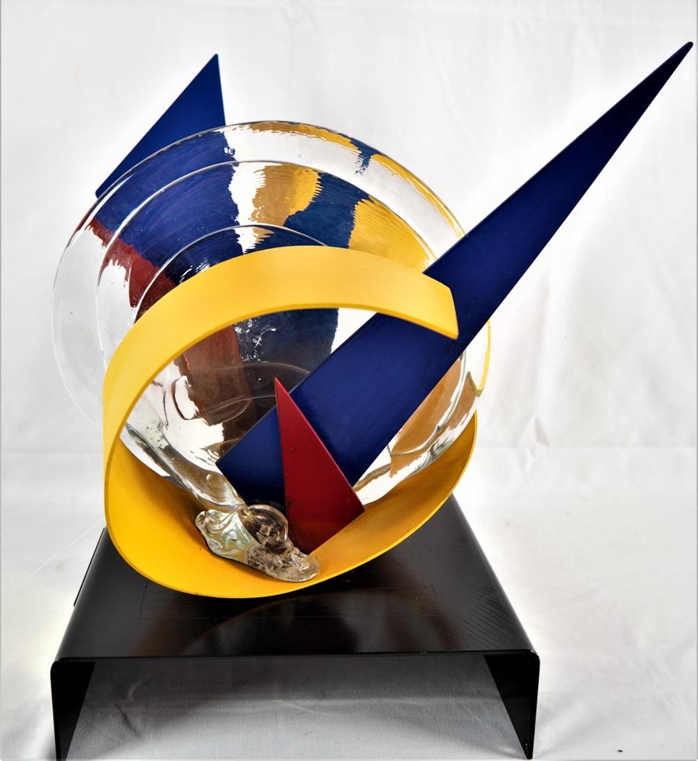 Roberto Lauro (*1932, Switzerland) - abstract: Roberto Lauro (*1932, Switzerland) - abstract glass-metal sculpture 2003 ribbed, colourless glass and metal, painted in red, blue and yellow. On curved, black lacquered base, there is a panel with a d