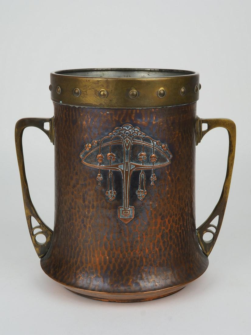 Vase with handle Art Nouveau around 1910: Vase with handle Art Nouveau around 1910made of metal (probably copper) and brass. Body in hammered design. Centered on both sides with floral decoration. Upper rim in brass, decorated with knobs. Two