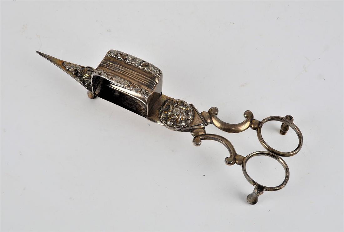 Wicking scissors around 1880: Wicking scissors around 1880made of metal, silver plated. With very beautiful tendril decorations, on the lower part with small feet. Curved handles. Several maker's marks. H. 4,5cm, l. 18cm.Dochtsche