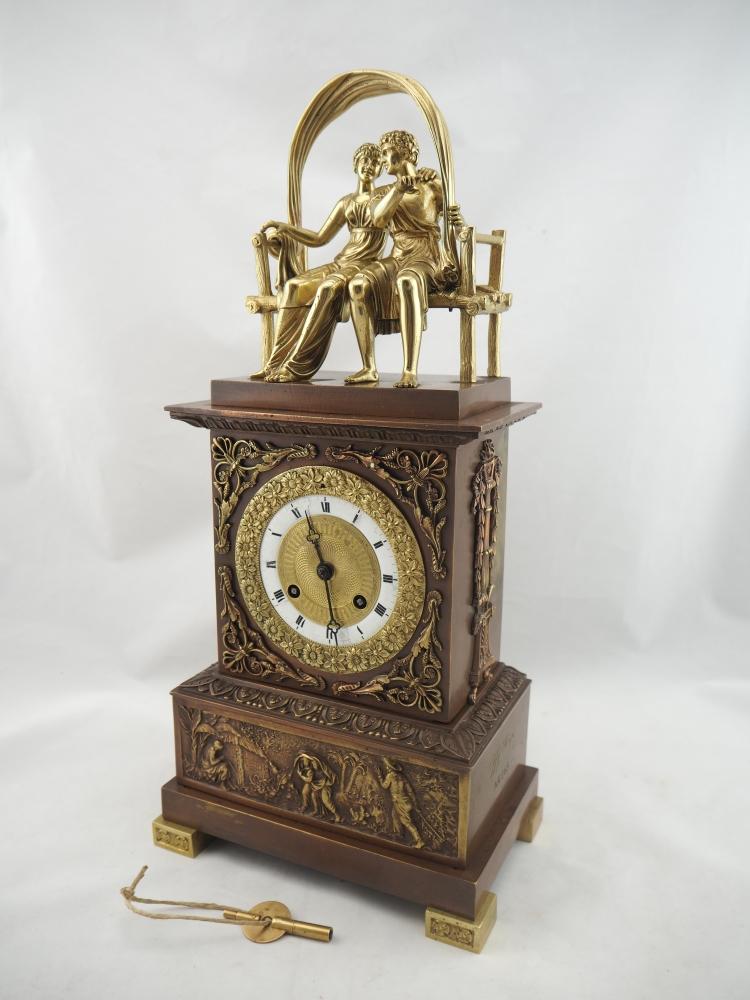 Empire mantelpiece clock around 1820: Empire mantelpiece clock around 1820Bronze case, partly patinated and gold-plated. Very filigree decorations. In the lower part a relief picture of a landscape with a staff set. Enameled dial with a w