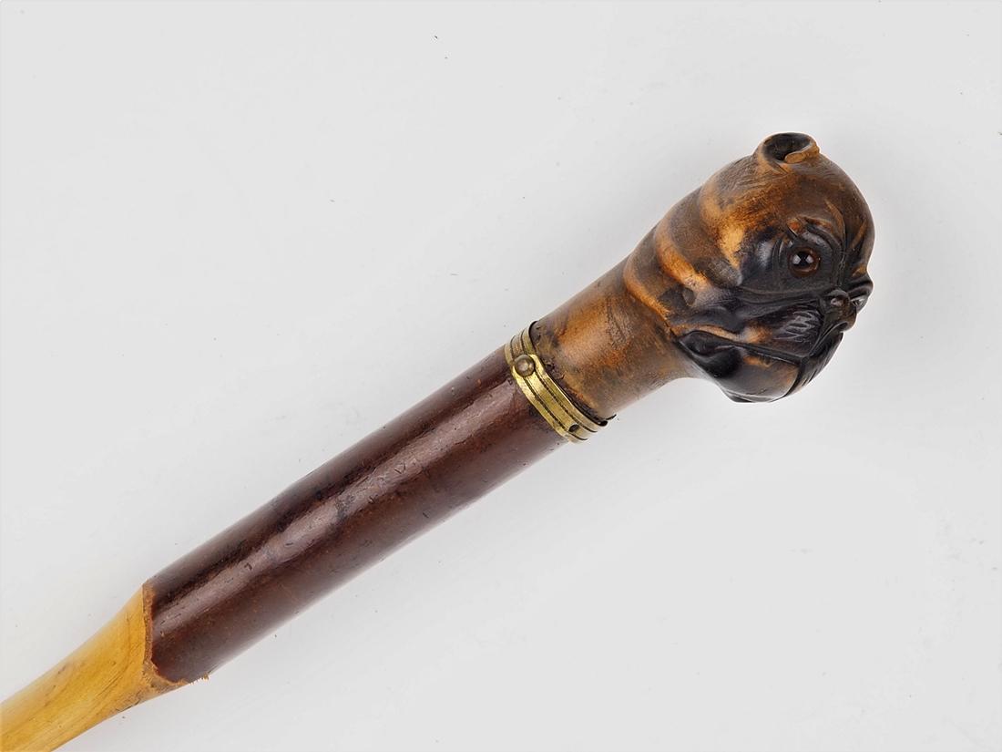Paper divider around 1800: Paper divider around 1800made of wood (probably cherry). Round handle, at the end with knob in the shape of a dog's head (bulldog) with glass eyes and blackened muzzle. With brass mount for hanging. L