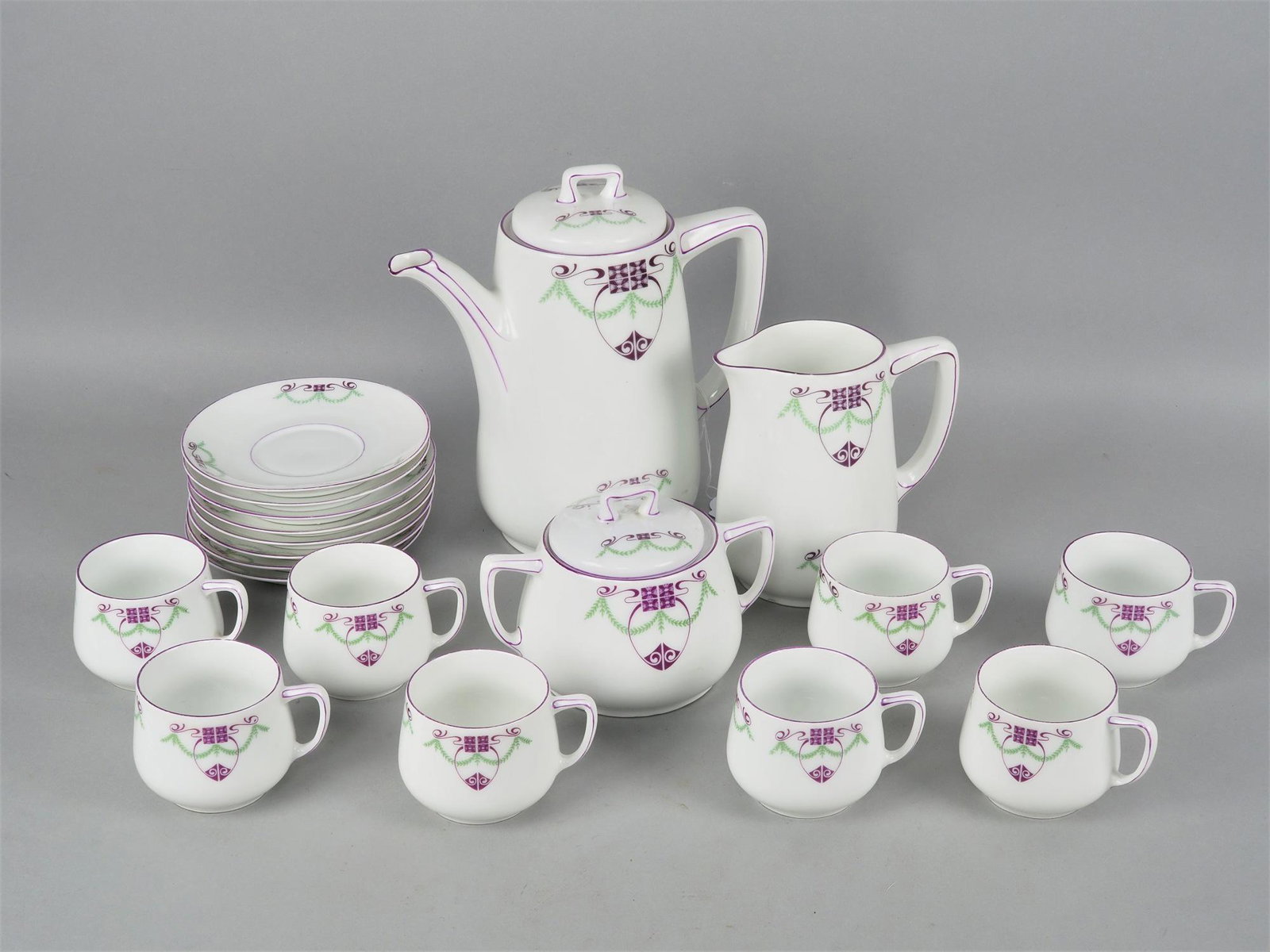 Coffee set with art nouveau decor: Coffee set with art nouveau decor Porcelain white, with green and purple art nouveau decoration. Consisting of coffee pot with lid, milk jug and sugar bowl, 8 cups, 8 saucers. Used condition, partly w