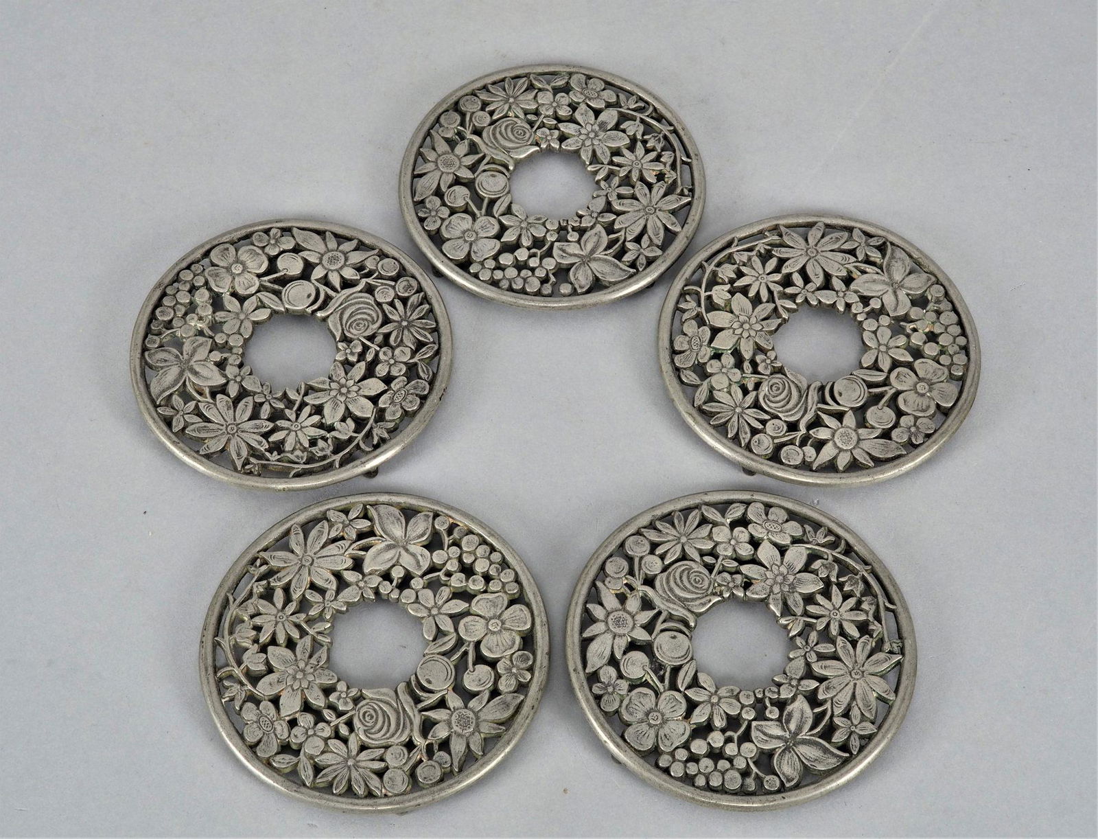 Coaster, art nouveau, 5 pieces: Coaster, art nouveau, 5 pieces made of pewter, openwork. Round, flat shape decorated with beautiful floral art nouveau motifs. On the bottom of each four small knobbed feet. Good used condition. Germa