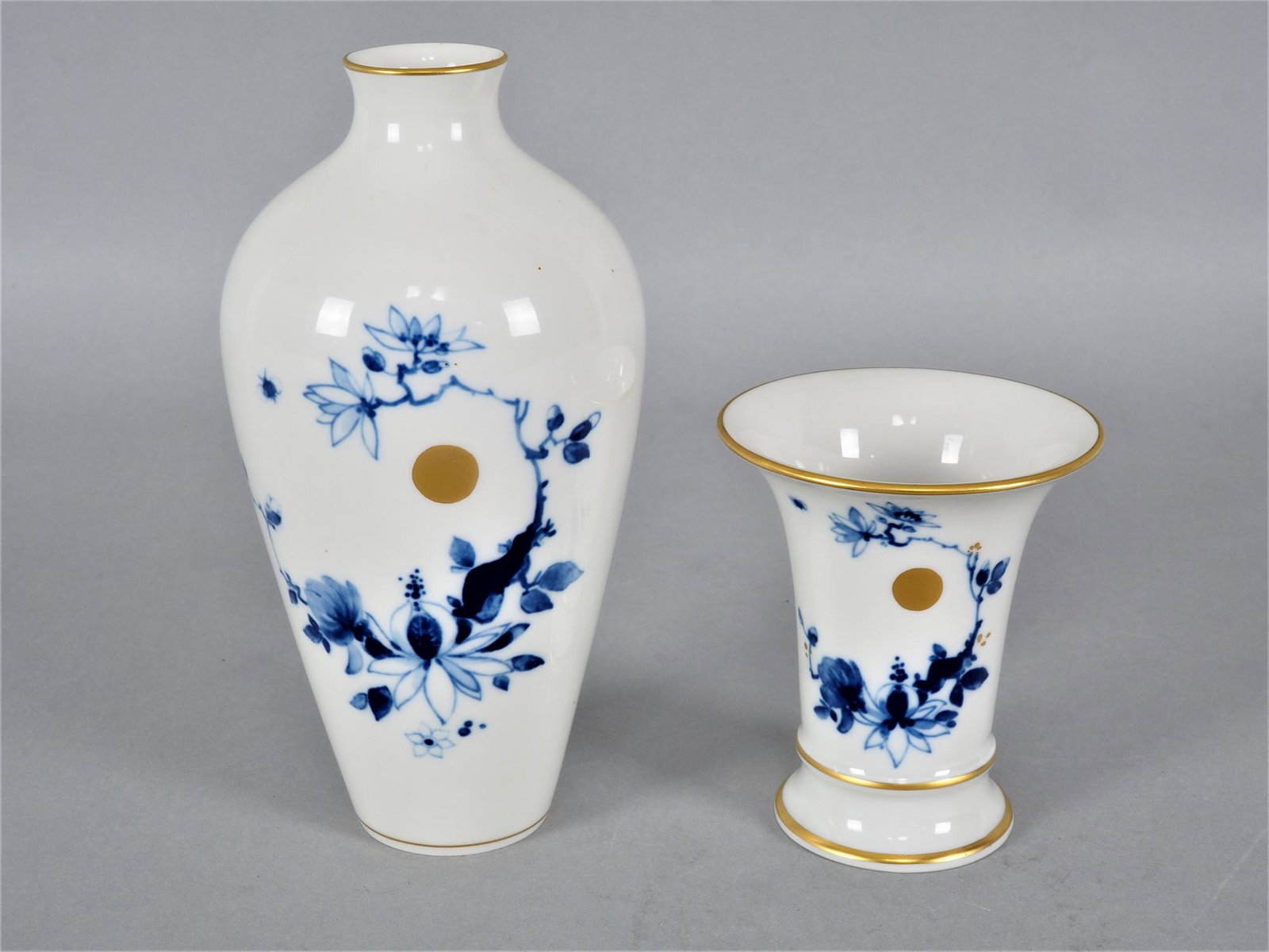 2 vases, Meissen, 1st choice.: 2 vases, Meissen, 1st choice. Porcelain, white glazed, with blue underglaze painting and gold decoration. One smaller vase, mouth opening upwards, at the bottom blue sword mark and stamped "50 E" and 