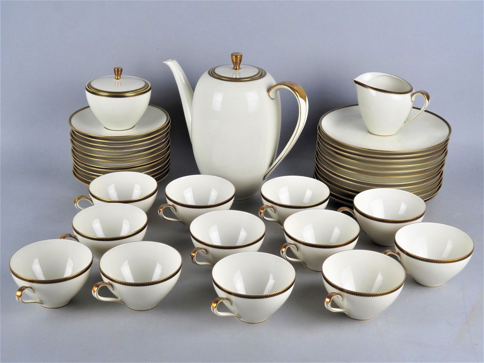 Coffee / tea service for 12 persons - Eschenbach Bavaria: Coffee / tea service for 12 persons - Eschenbach Bavaria Porcelain eggshell-colored, with gold decoration and checkerboard pattern on the rim. Consisting of 12 cups for coffee or tea, 12 coasters, 12