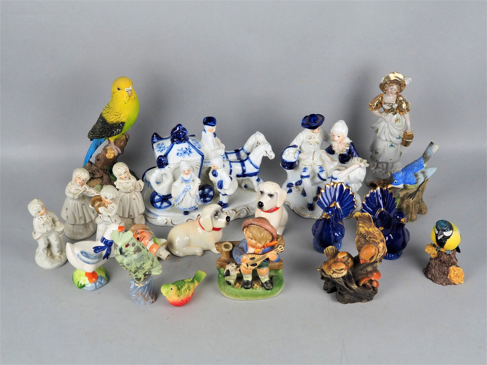 Large convolute showcases objects: Large convolute showcases objects Consisting of birds, various representations, a children's band, rococo carriage and figurines, mostly made of porcelain, few of mass, total 20 pieces. Until H. 20cm 