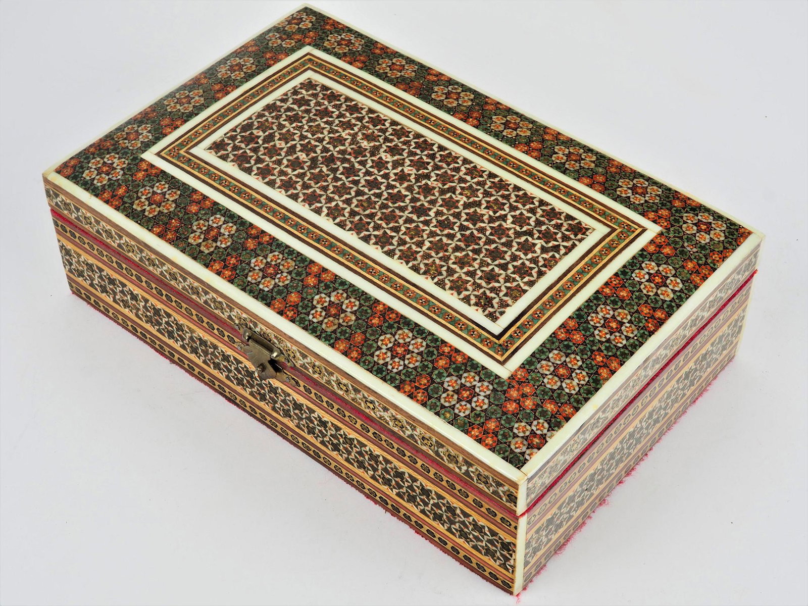Jewelry box, 70s: Jewelry box, 70s Case made of hardwood. Rectangular shape, lid bulged to the top. Richly inlaid with bone and other decorations. Interior lined with red fabric. Good condition. H. 8cm, w. 25cm, d. 16c