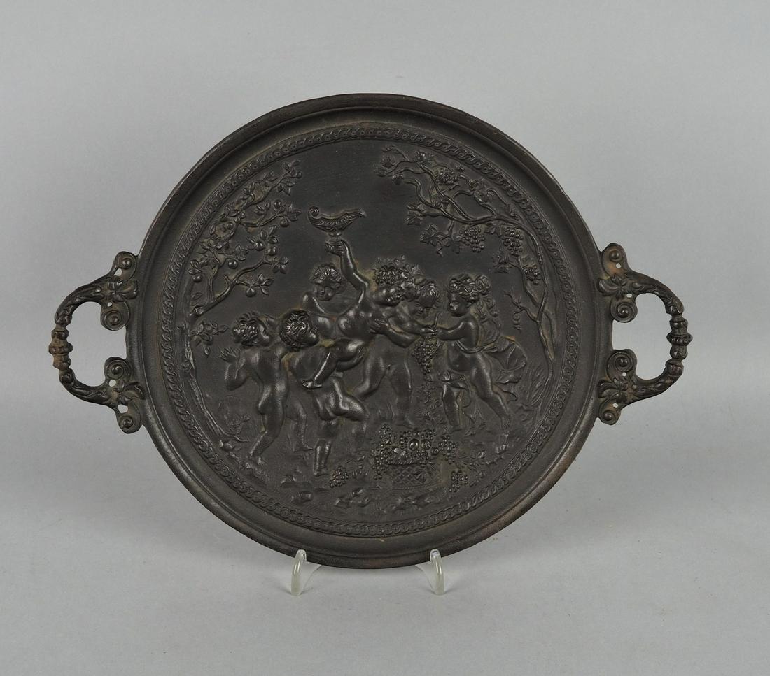Ornamental plate Berlin iron, around 1880: Ornamental plate Berlin iron, around 1880Very fine iron casting, round shape with handles. Front side decorated with a putto vine in relief, sides decorated with vines and grapes, back side with model