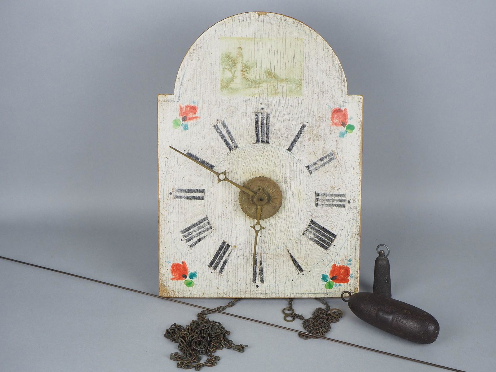 Rural wall clock, around 1800: Rural wall clock, around 1800Wall clock with open movement, strike on spring & bell. Wooden dial with black Roman numerals, two brass hands and floral polychrome painting. Dimensions ca. 22 x 32 cm. A