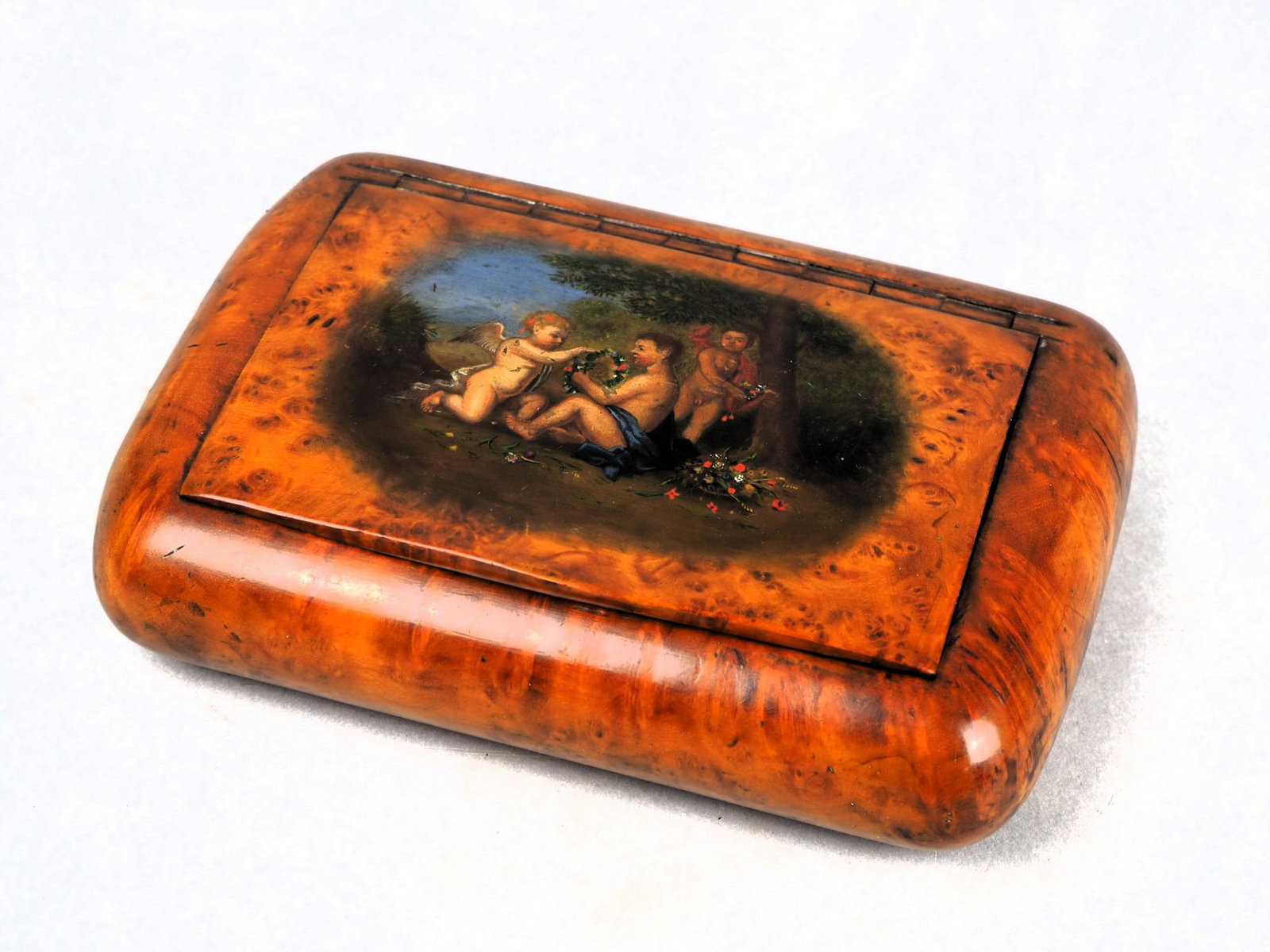 Bird's eye maple tobacco box, 19th c.: Bird's eye maple tobacco box, 19th c.Smoothly polished rectangular box made of Bird's Eye Maple with rounded walls and recessed hinged lid, painted with a depiction of Cupid playing with two naked boy
