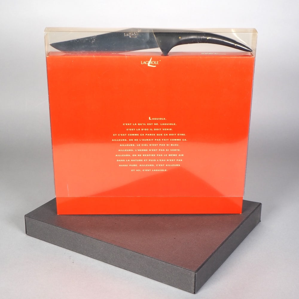 Laguiole designer cheese knife by Philippe Starck: Laguiole designer cheese knife by Philippe Starckin OVP, as book slipcase with transparent plastic overlay. Very sharp stainless steel blade, with riveted black Bakelite handle. L. 30cm. This design "