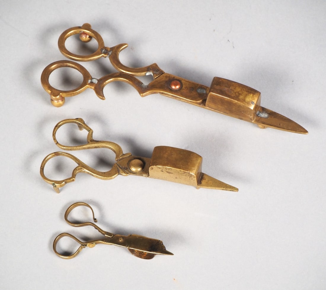 Wick trimmers assortment, 19th c.: Wick trimmers assortment, 19th c.Three brass wick trimmers. Length ca. 8-18 cm. With signs of age and wear.Konvolut Dochtscheren, 19. Jh.Drei Dochtscheren aus Messing. Länge ca. 8-18 cm. Mit Alters- 