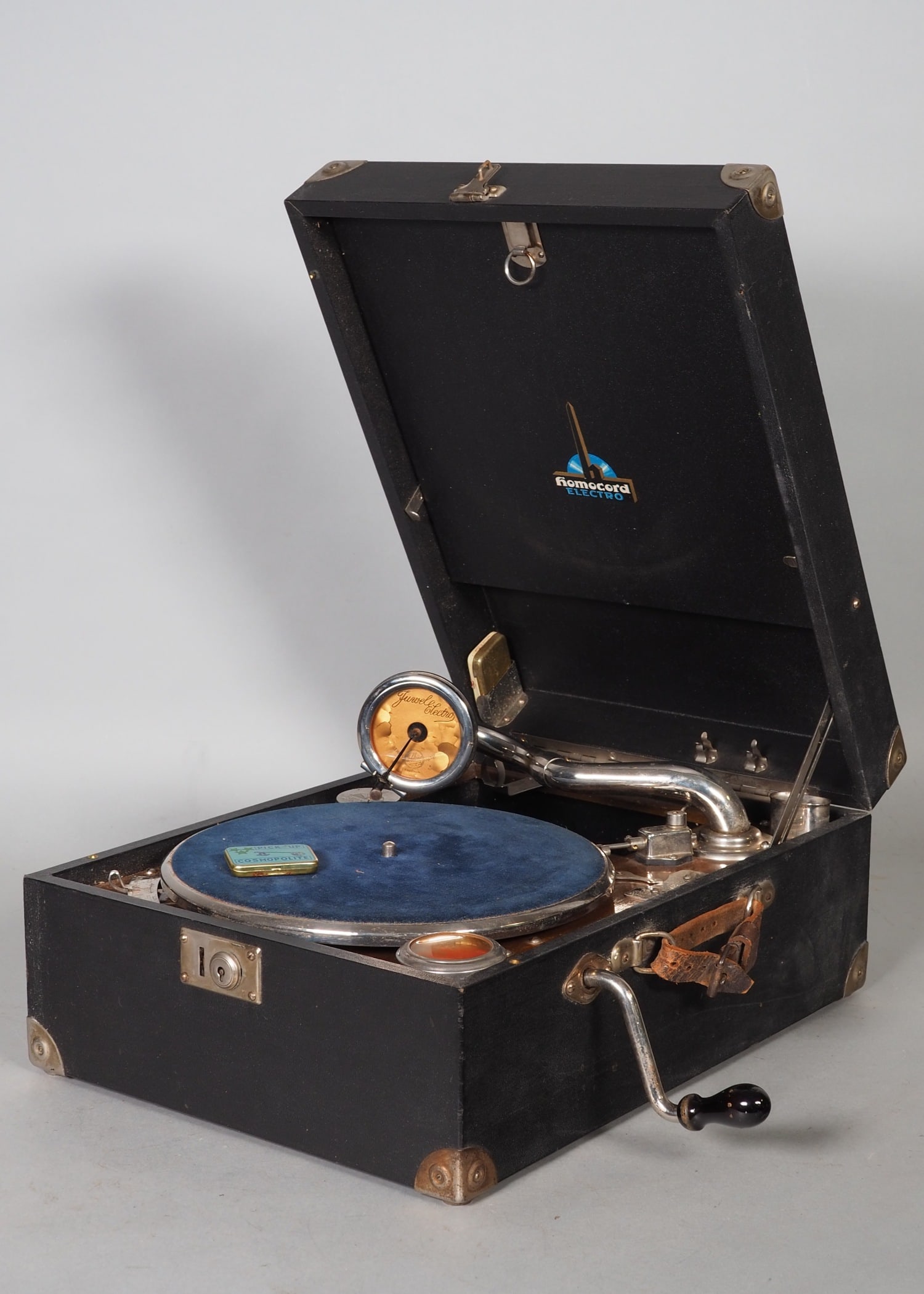Travel gramophone 1920/30s, Homocord Electro: Travel gramophone 1920/30s, Homocord ElectroSuitcase gramophone around 1930 with crank or electric. Funnel and sound box intact. Lid inside with hinged record holder incl. 5 shellac records, lid with 