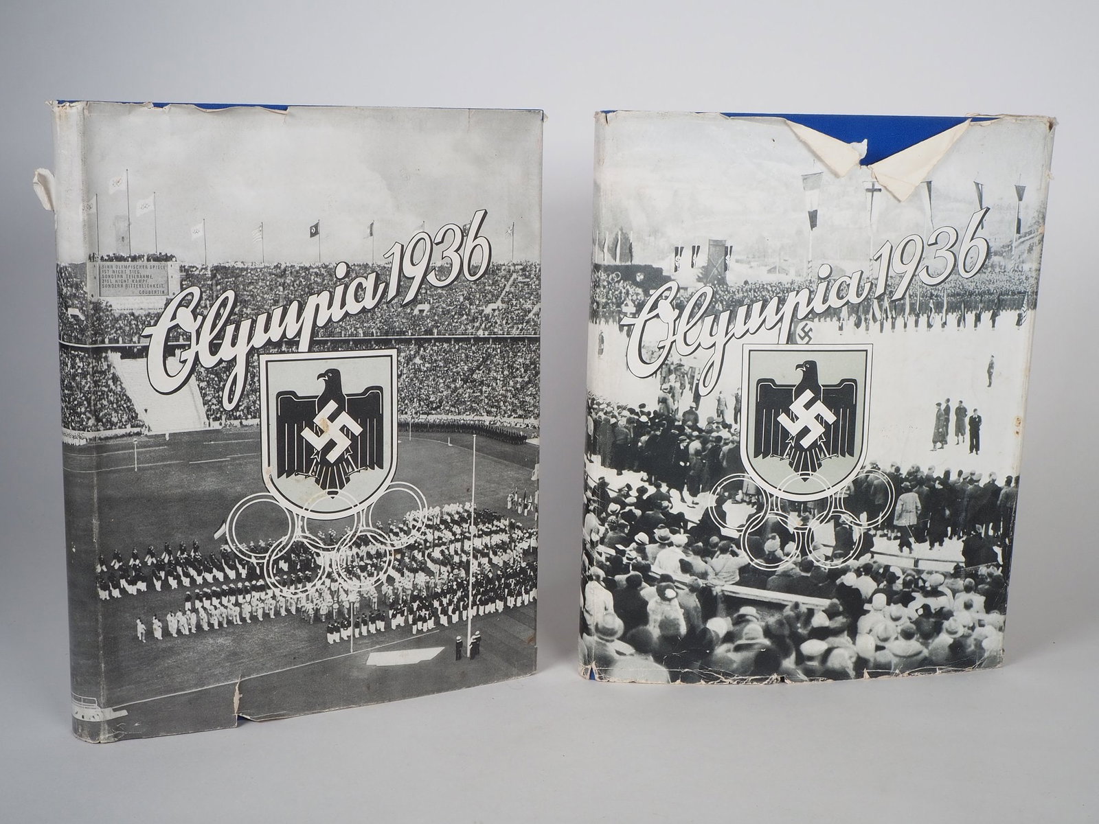Pair of collector's picture albums, Olympia 1936, Vol. 1 & 2: Pair of collector's picture albums, Olympia 1936, Vol. 1 & 22 cigarette collectors albums, volume 1 & 2, both with original dust jacket, illustrated Reichsadler with swastika. Good condition. Each 25 