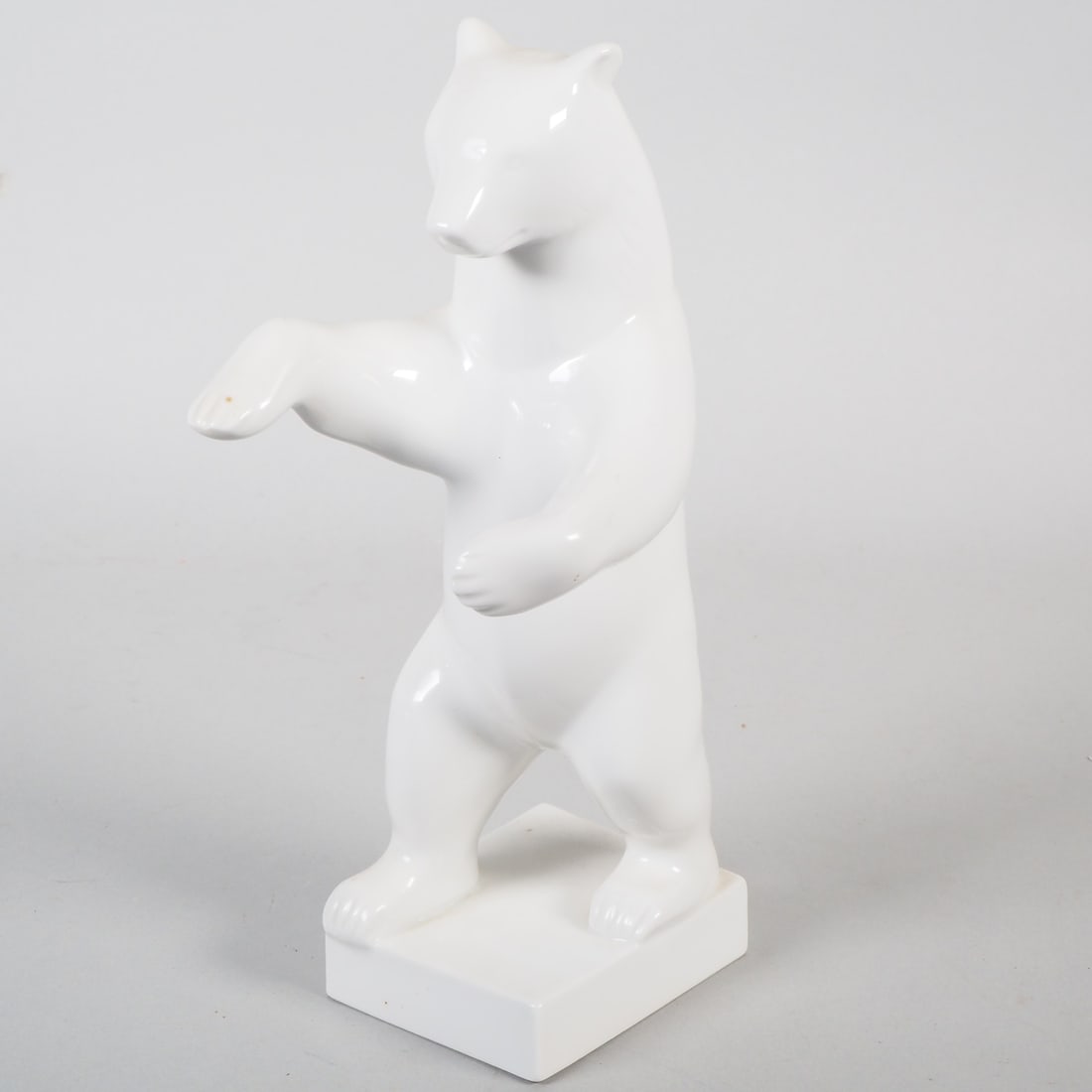 K.P.M., Standing bear: K.P.M., Standing bear Porcelain, glazed white. A bear standing on a square stand, depicted in motion. Blue sceptre mark on the base, intact. Height 25 cm.K.P.M., Stehender BärPorzellan, weiß