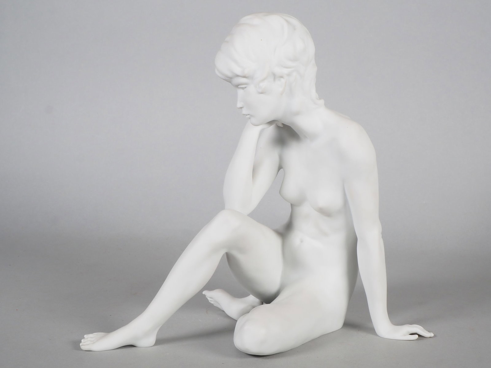 Kaiser porcelain figurine nude; "The contemplative",: Kaiser porcelain figurine nude; "The contemplative", Made of bisque porcelain. Naked young woman, her head resting suggestively in her hand, her elbow resting on her thigh. Her facial expression is pe