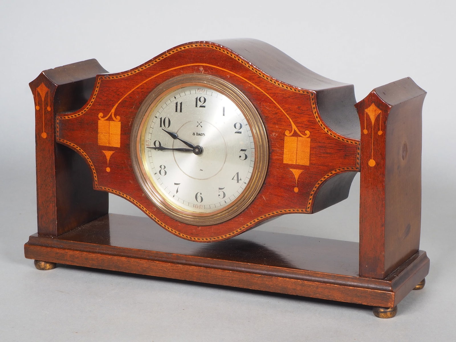 Art Deco table clock (8 days), circa 1920: Art Deco table clock (8 days), circa 1920 Very fine clock in a wooden case, mahogany veneered, with light-coloured inlays in maple. Built-in movement with 8-day power reserve. Silver-plated dial and b