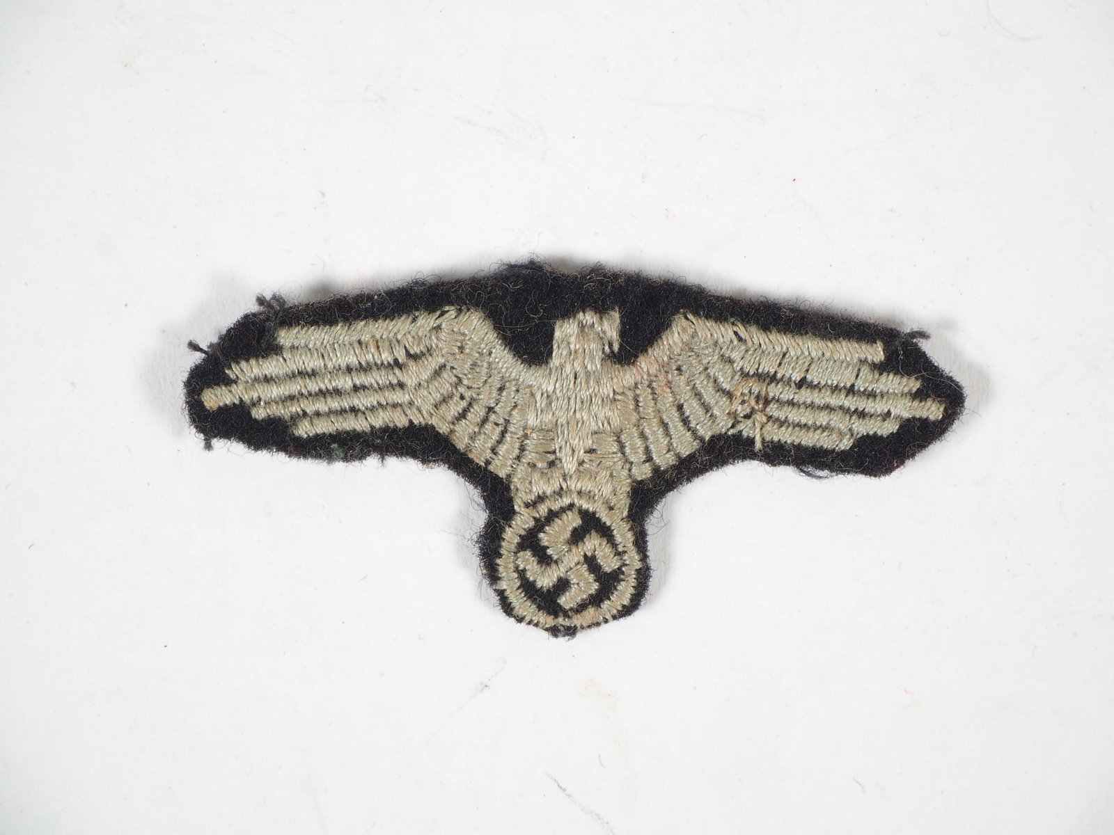 Waffen-SS cap eagle machine embroidered teams WK2: Waffen-SS cap eagle machine embroidered teams WK2 Cap eagle detached from the cap for the Waffen-SS shuttle or field cap WK2. Used condition, untested piece. Waffen-SS Mützenadler maschinengestickt M