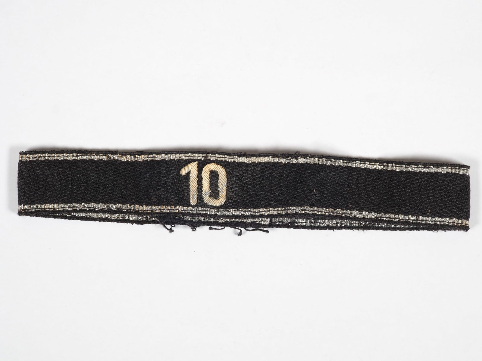 General SS sleeve band foot standard 10 “Pfalz: General SS sleeve band foot standard 10 “Pfalz” Black woven ribbon with embroidered storm number "10", silvering largely rubbed off, woven silver edge strip with fine metal thread. Ends origin