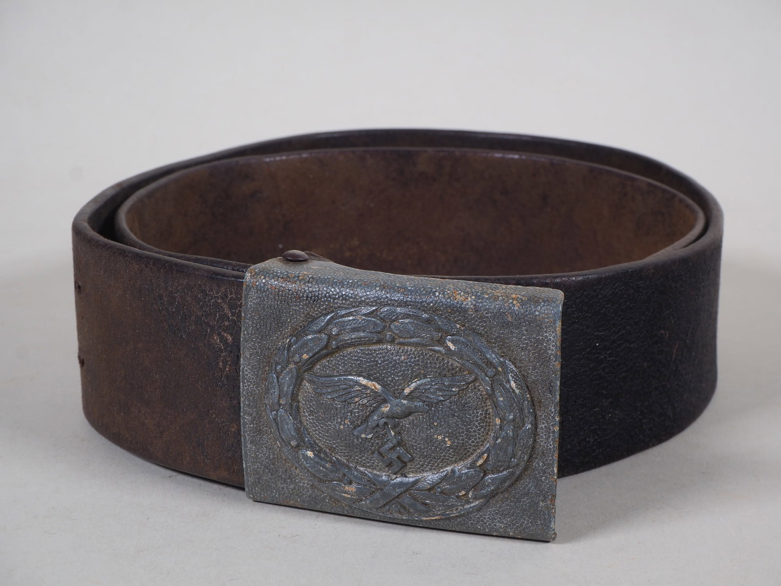 Luftwaffe (WH) belt buckle for enlisted, 1st model, E. Schneider Lüdenscheid 1942: Luftwaffe (WH) belt buckle for enlisted, 1st model, E. Schneider Lüdenscheid 1942 Grained sheet metal, non-magnetic. With attached medallion featuring Luftwaffe eagle in laurel wreath, swastika intac
