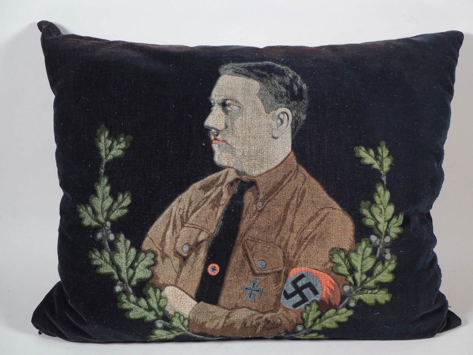 NS propaganda pillow Adolf Hitler, 1930s: NS propaganda pillow Adolf Hitler, 1930s Early Nazi propaganda pillow, front with black velvet printed Adolf Hitler motif, seen in brown shirt with swastika armband in oak leaf half wreath. Back with