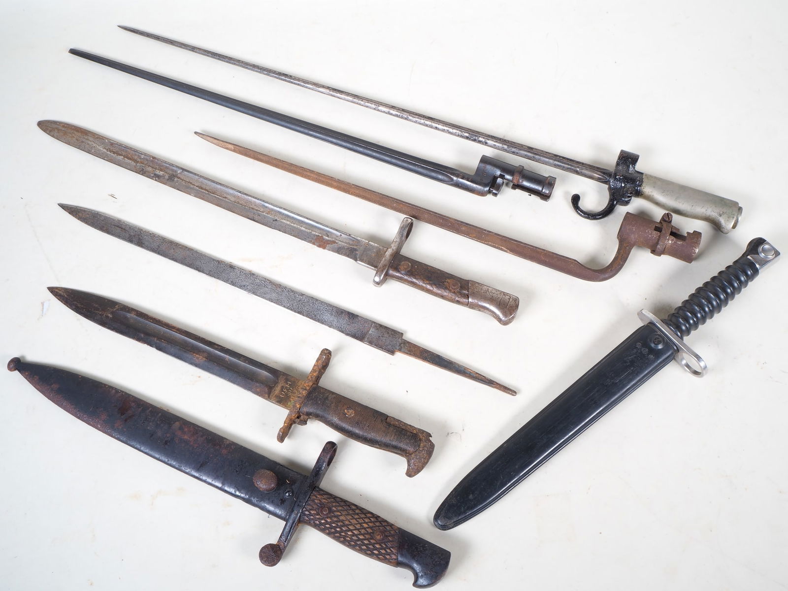 Set of old bayonets, 7 pieces: Set of old bayonets, 7 pieces 1.) Switzerland: M 1957 dagger bayonet - for SIG 510, with scabbard. 2.) French sleeve bayonet. 3.) Soviet Union: Mosin-Nagant M 91/30 bayonet. 4.) France: M 1886 Lebel s