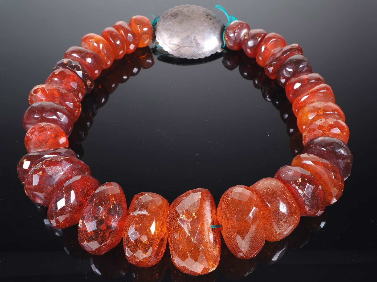 Huge traditional amber wedding necklace, circa 1800: Huge traditional amber wedding necklace, circa 1800Magnificent Biedermeier traditional necklace made of faceted amber pieces, cord renewed, with large oval silver clasp, fine engraving with a pair of