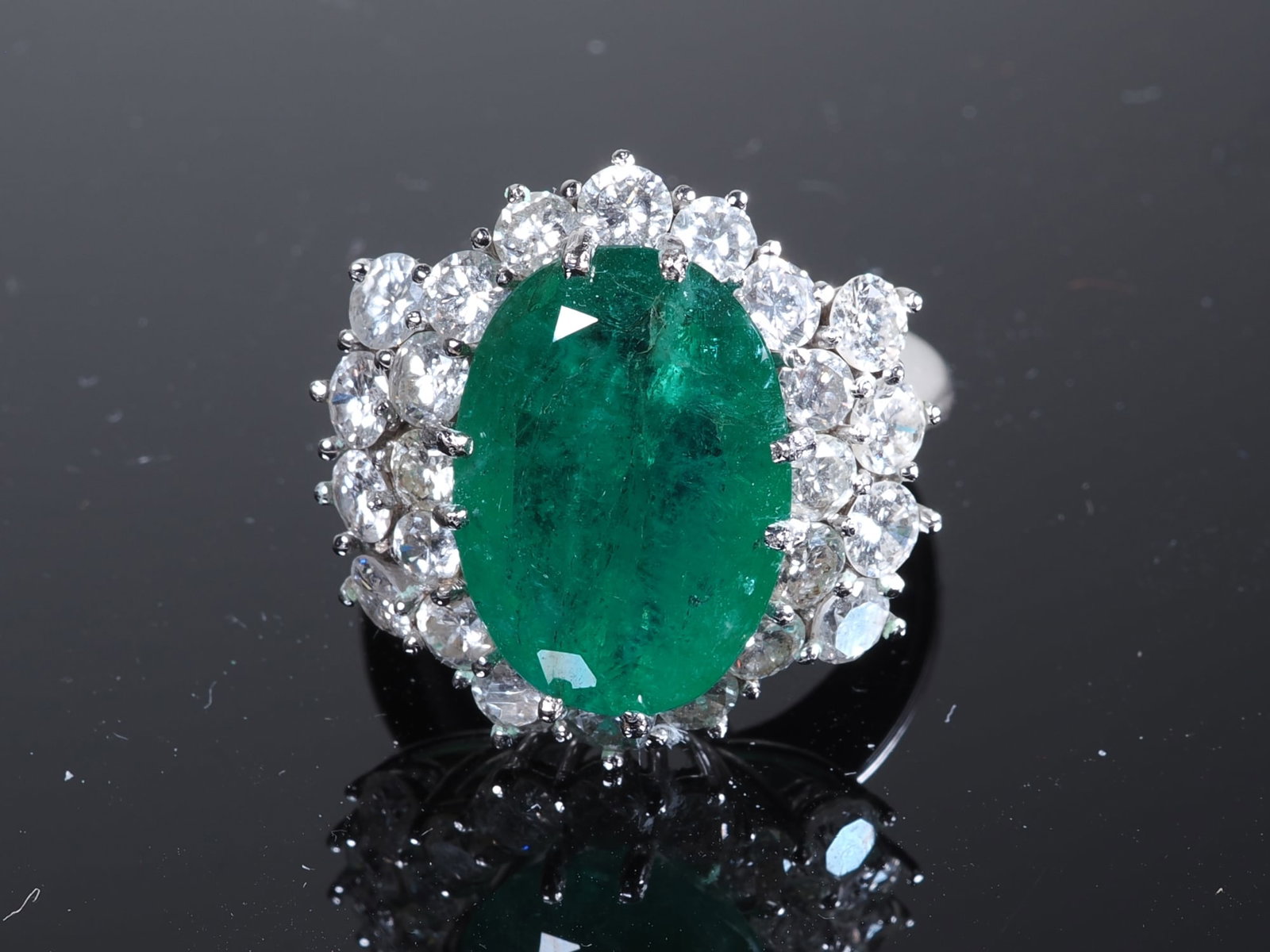 Emerald and diamond ring in 18-carat white gold: Emerald and diamond ring in 18-carat white goldLarge centre-set emerald and 24 diamonds, total weight 12.2 g.