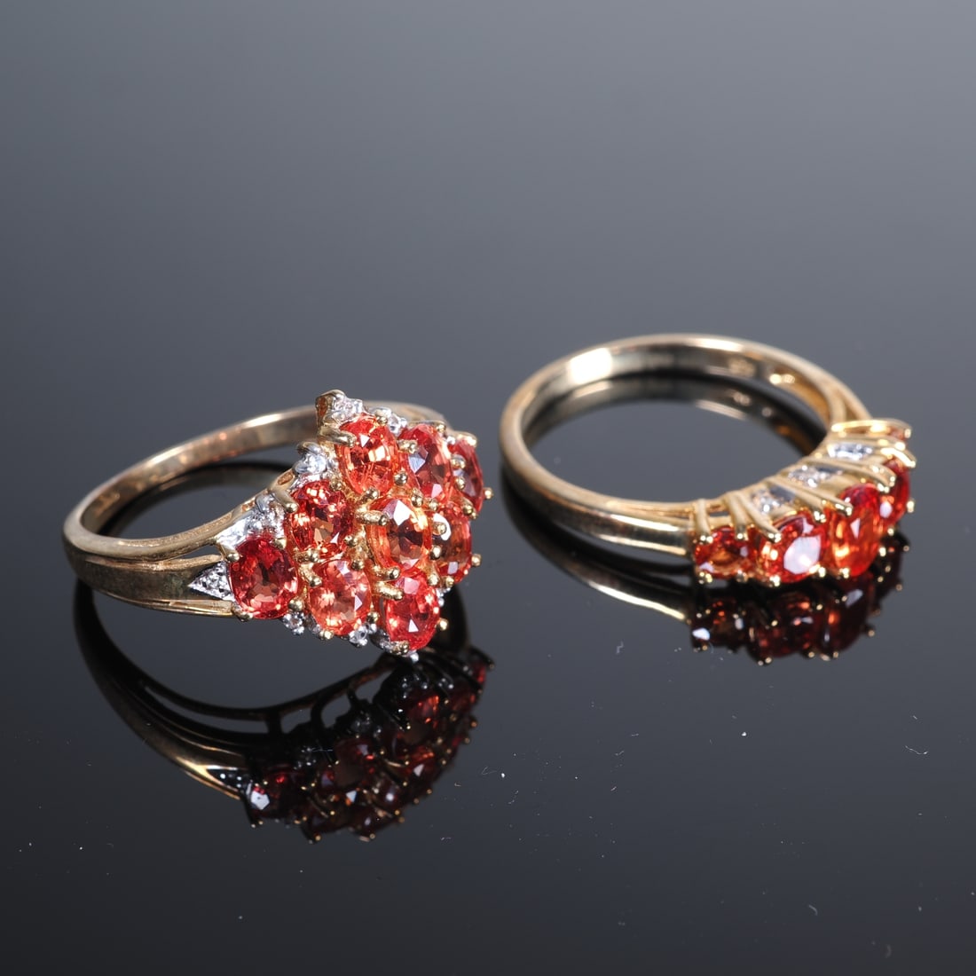 2 ladies’ rings with sunset rubies, 9ct yellow gold: 2 ladies’ rings with sunset rubies, 9ct yellow goldAll 375/000 yellow gold with Juwelo certificates. 1.) Sunset ruby with a central 0.35ct stone, plus 4 further rubies totalling 0.8ct and 6 small