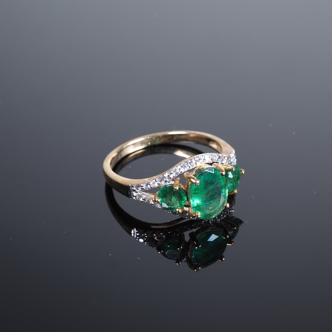 Zambia Emerald Gold Ring: Zambia Emerald Gold Ring9ct yellow gold, 375/000 fineness, ring head set with a large oval emerald approx. 0.88ct and 2 emeralds totalling 0.44ct, as well as a band set with 34 white sapphires,