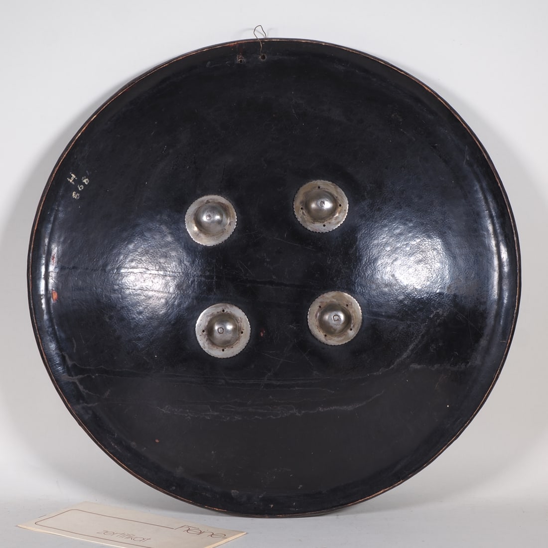 Protective shield made of rhinoceros skin, India, 19th century.: Protective shield made of rhinoceros skin, India, 19th century.Antique shield made of rhinoceros skin, black lacquer finish, curved shape, padded holder with velvet cushion and straps, attached to iro