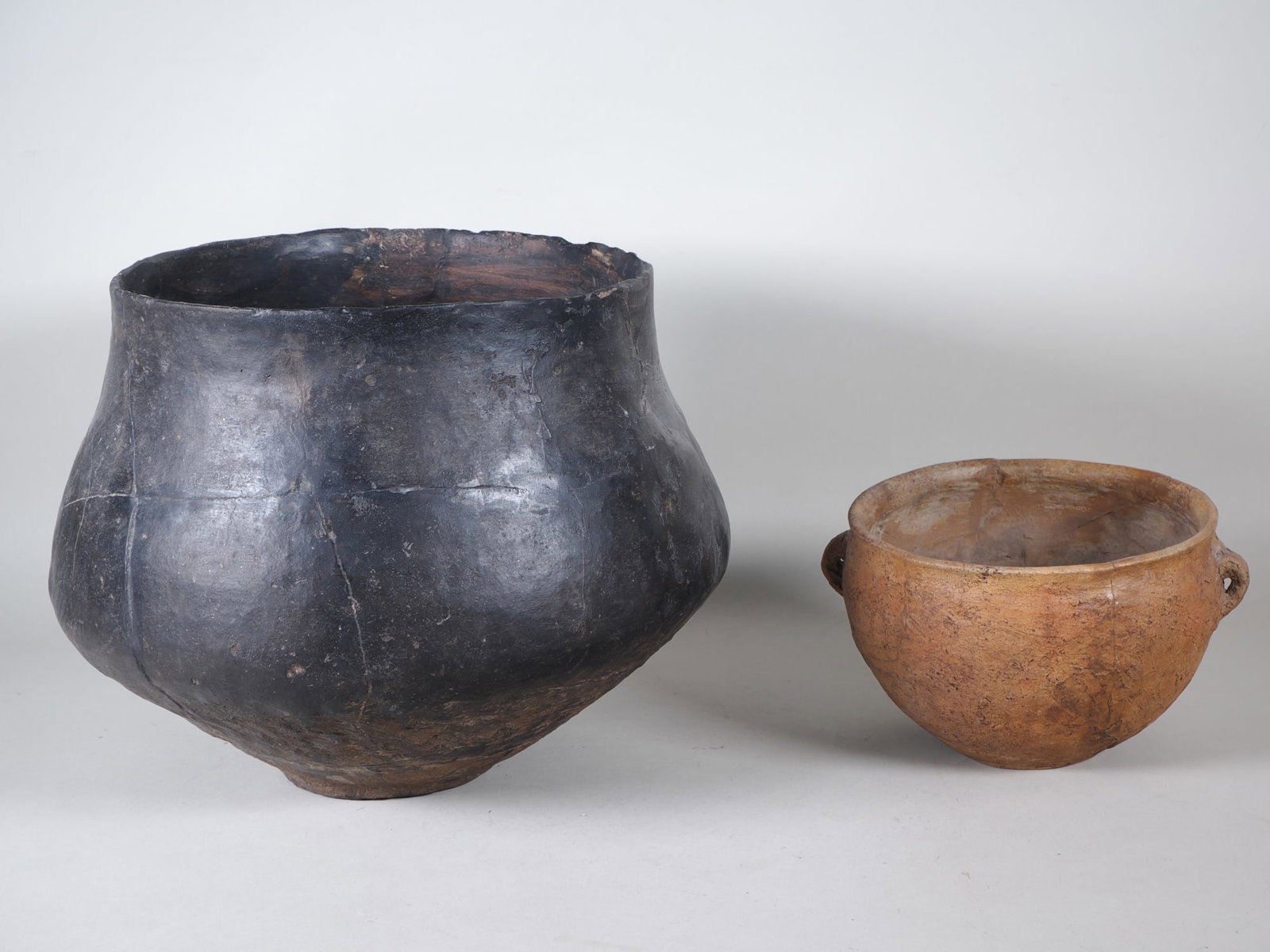 Large urn and small pot with handles, Lusatian culture, c. 1300-500 BC.: Large urn and small pot with handles, Lusatian culture, c. 1300-500 BC.Clay, beautiful bulbous urn, restored, height 27 cm, diameter 35 cm. Provenance: Zeller Lindau auction (cat. 83/815). Small pot w