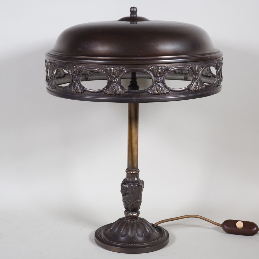 Art Deco table lamp around 1920: Art Deco table lamp around 1920brass lamp base and shade, wide round stand tapering upwards, fluted shaft decorated with female faces and foliage, double E27 socket attached to the top and large round