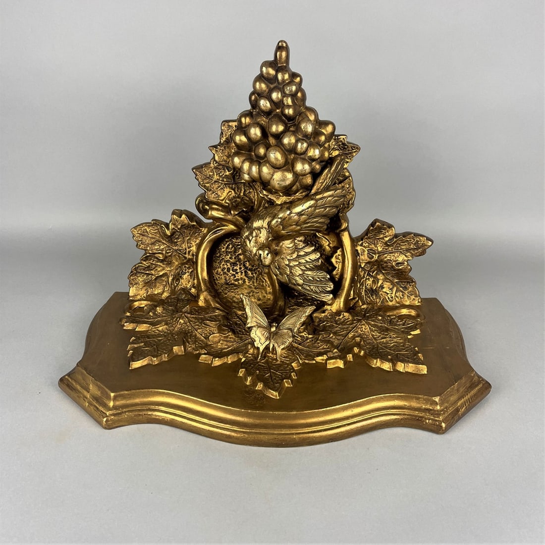Wall console, around 1900: Wall console, around 1900Wood with plaster overlay, gilded. Curved plate, under it a very finely crafted bird on a vine with grapes looking at a butterfly. Approx. dimensions 35x48x26 cm. With signs o