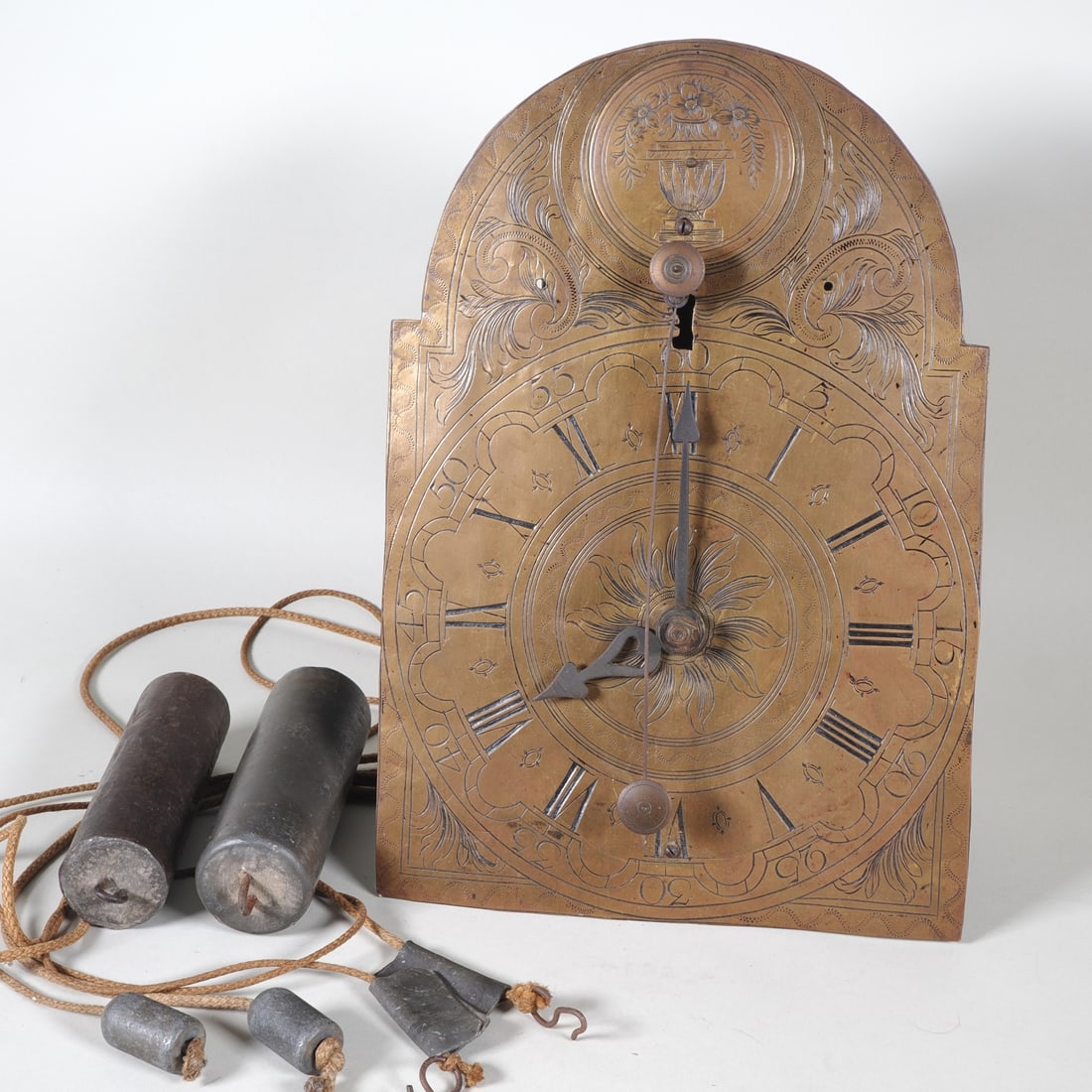 Baroque front-winding clock: Baroque front-winding clockLarge iron movement with some brass wheels; driven by cord-winding and weights; spindle escapement with a short cowtail pendulum above the dial, which is made of brass with