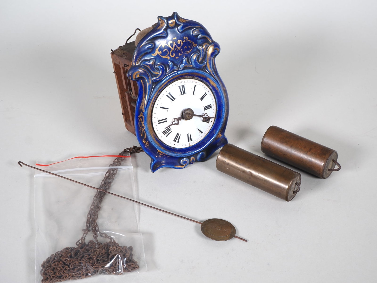 Jockel clock, Black Forest, c. 1880: Jockel clock, Black Forest, c. 1880Small teardrop-shaped porcelain dial, painted and glazed in blue and gold; white, slightly domed dial with black Roman numerals; original steel hands; small