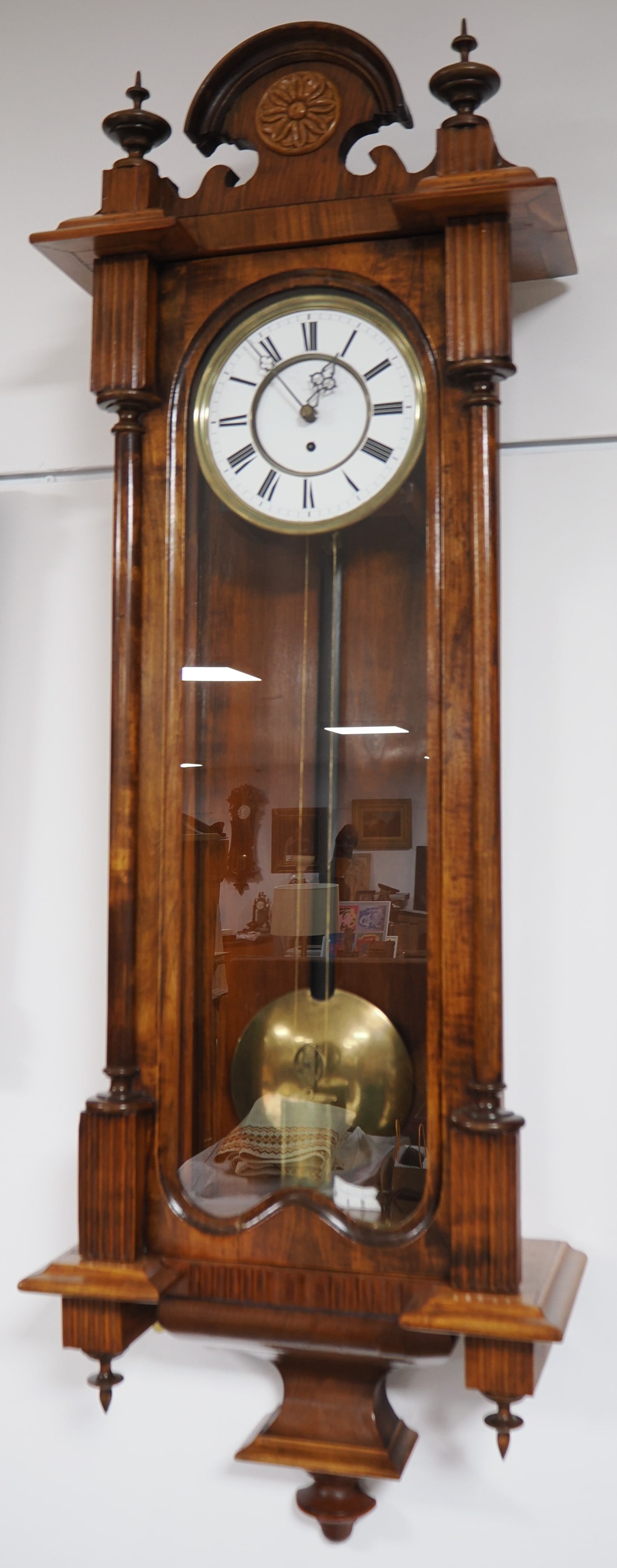 Regulator clock, circa 1890: Regulator clock, circa 1890Wooden case (probably cherry wood), glazed on three sides, with a door at the front, upper section featuring a decorative finial, movement mounted on a slide with solid bras