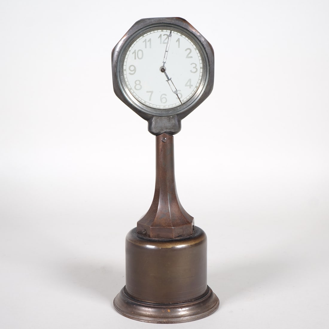Mysterious clock, 1920s: Mysterious clock, 1920sPatinated metal case in the shape of a street lamp, with a wide, round base tapering upwards. The upper section features a dial glazed on both sides, with hands connected to the