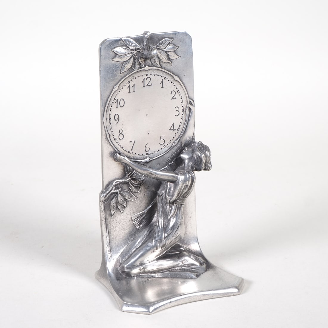 Art Nouveau pocket watch stand: Art Nouveau pocket watch standMade of pewter, featuring a depiction of a watch, with a lady in relief below holding it aloft; in good condition. H. 15cm W. 8.5cm D. 7cm