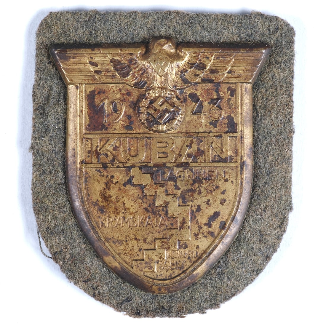 Kuban badge, Wehrmacht Army: Kuban badge, Wehrmacht ArmyKuban sleeve badge on field grey cloth backing for WH Army, non-ferrous metal bronzed, all pins intact on the back, with backing plate and remnants of paper cover. Removed f
