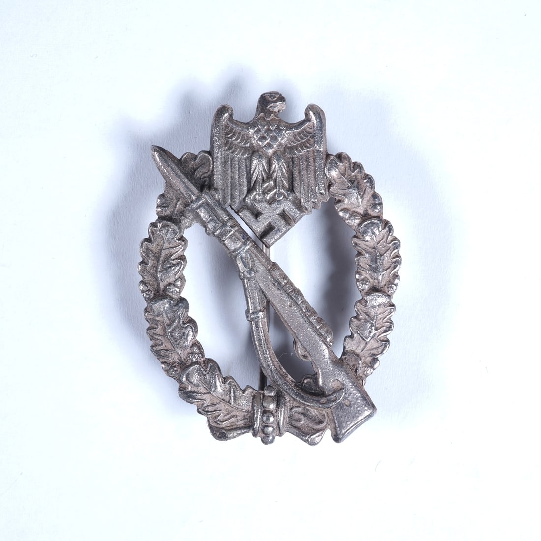 Infantry Assault Badge in Silver: Infantry Assault Badge in SilverFine zinc version, silver plating still largely intact; characteristic small bubbles visible beneath the silver plating on the reverse; slight oxidation in a small area