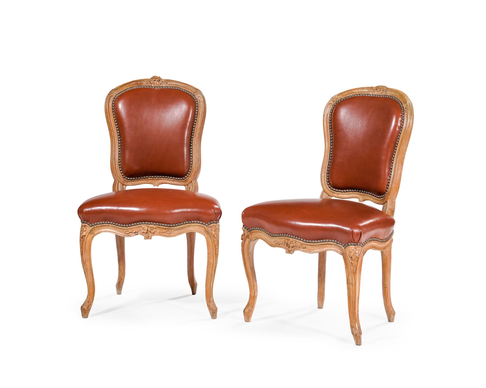 Paire de chaises d'époque Louis XV, en hêtre mouluré et sculpté de fleurettes, a: Paire de chaises d'époque Louis XV, en hêtre mouluré et sculpté de fleurettes, assise et dossier garnis de similicuir fauve, pieds galbés, trace d'estampille sur une chaise Co