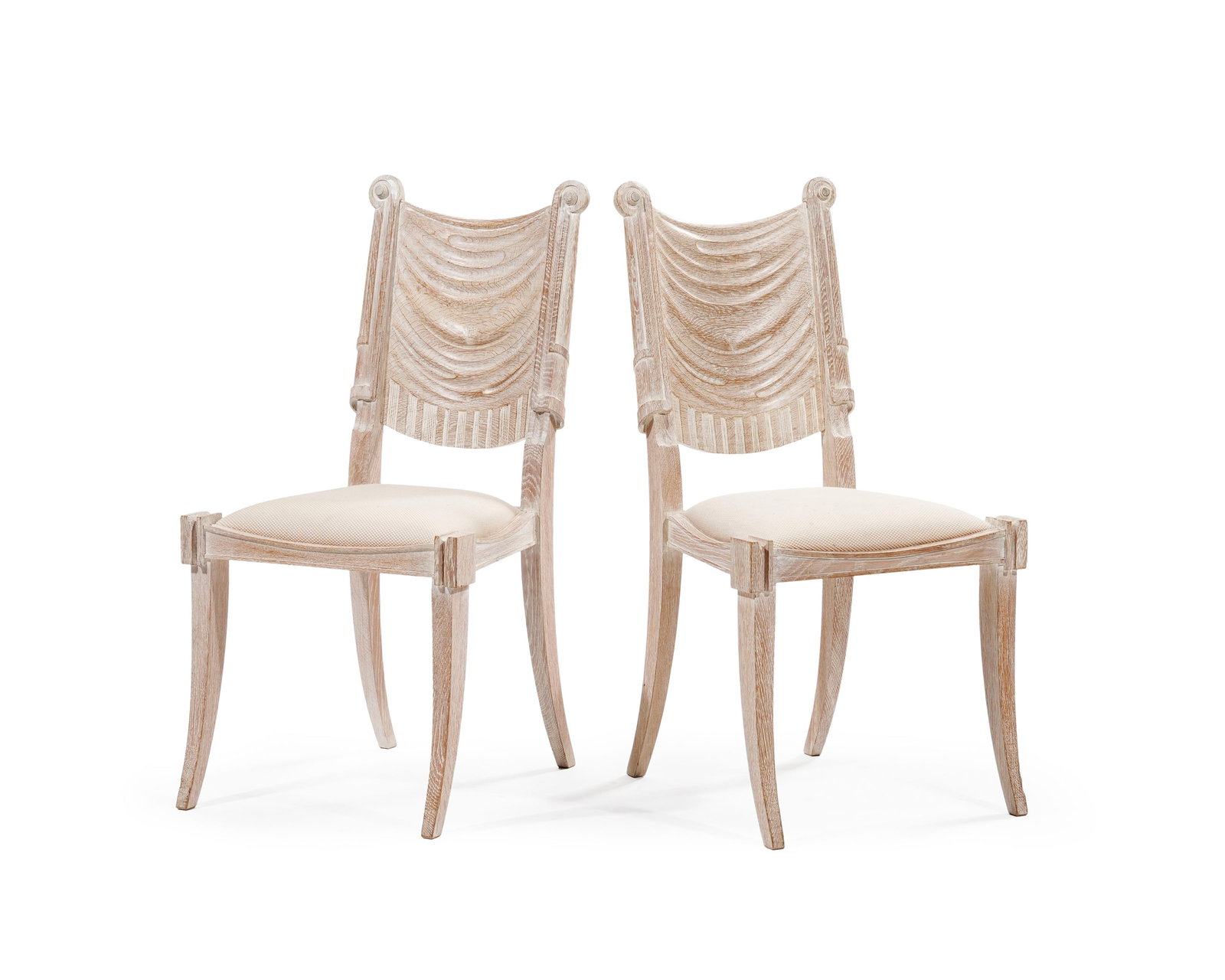 Paire de chaises de style Klismos, XXe s., en chêne sculpté et patiné, garniture de l: Paire de chaises de style Klismos, XXe s., en chêne sculpté et patiné, garniture de l'assise en tissu crème, dossier à décor de draperie Condition taches sur la garniture
