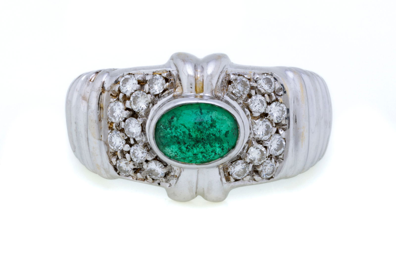 Bucherer, bague or gris 750 à motif godronné centrant un cabochon d'émeraude épa: Bucherer, bague or gris 750 à motif godronné centrant un cabochon d'émeraude épaulé de diamants taille brillant, doigt 54-14, 6g Condition Monture: Bon état de conservati