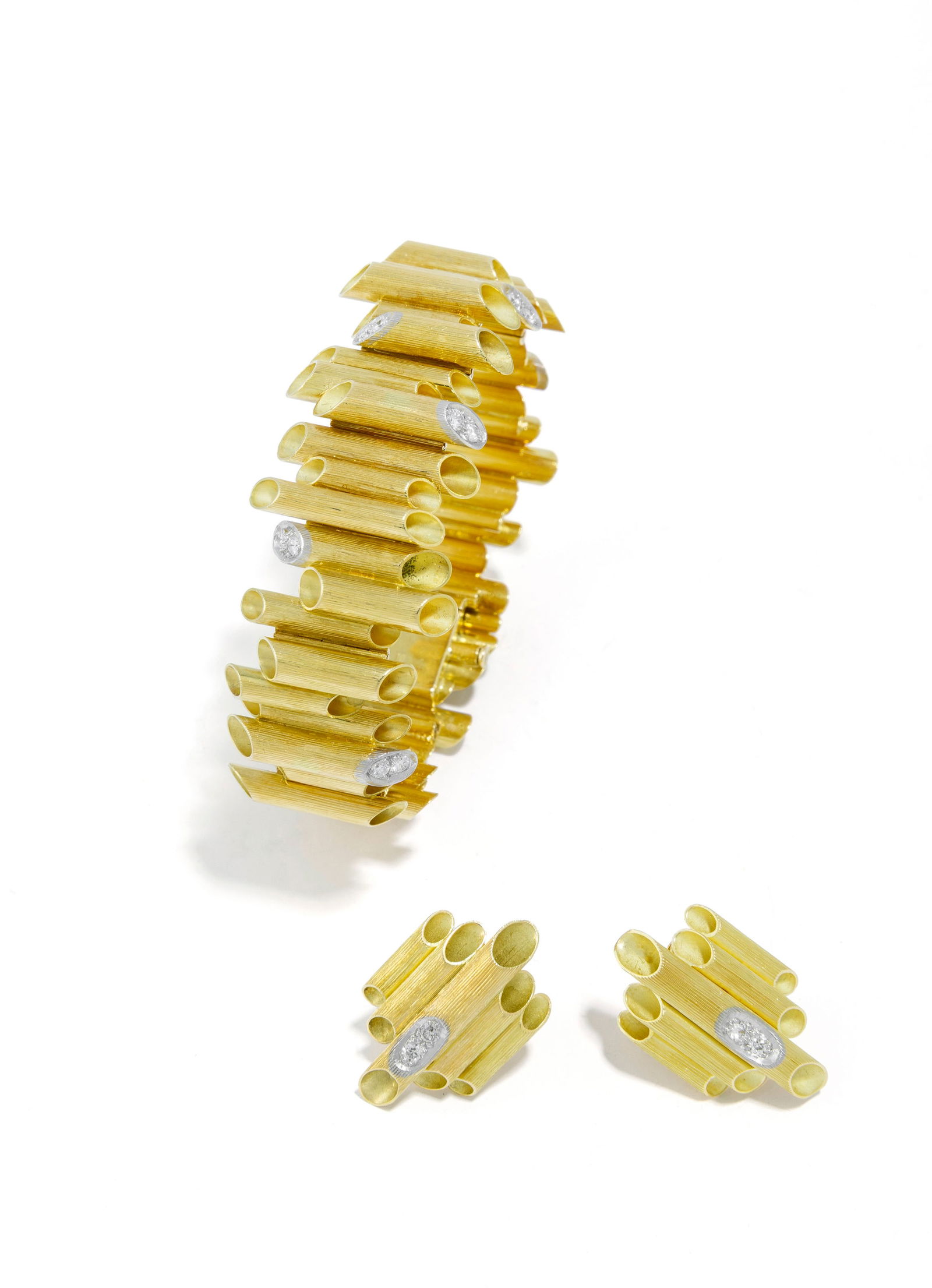 Grima, ensemble composé d'un bracelet et d'une paire de boucles d'oreilles, années 1972 et 1975 en: Grima, ensemble composé d'un bracelet et d'une paire de boucles d'oreilles, années 1972 et 1975 or 750 composés d'une succession d'éléments tubulaires aux extrémités biseautées dont certaines