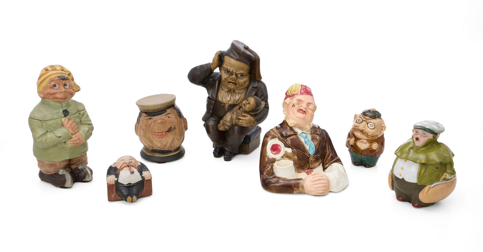 "Grotesque et grimaçant", réunion de 7 pots à tabac en céramique (dont porcelain: "Grotesque et grimaçant", réunion de 7 pots à tabac en céramique (dont porcelaine) polychromes, figurant des têtes caricaturales aux traits exagérés : joues pleines,