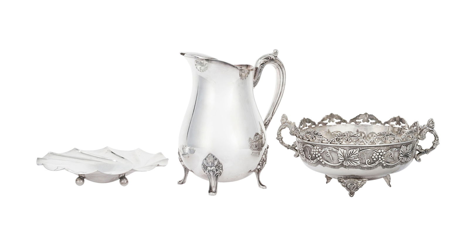 Ensemble de 3 pièces en métal argenté, XXe s., comprenant: 1 pichet à anse feuil: Ensemble de 3 pièces en métal argenté, XXe s., comprenant: 1 pichet à anse feuillagée, 1 coupe à anses à décor de grappes de raisins et 1 coupelle tripode