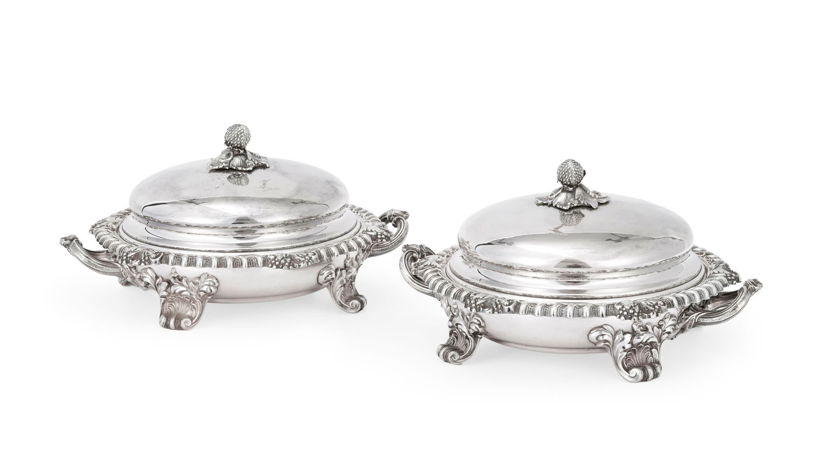 Paire de chafing dish en métal argenté anglais, à décor de godrons, grappes de r: Paire de chafing dish en métal argenté anglais, à décor de godrons, grappes de raisins et la prise fraise, couvercle gravé d'un bras héraldique, h. 14,5 cm, diam. 23,5