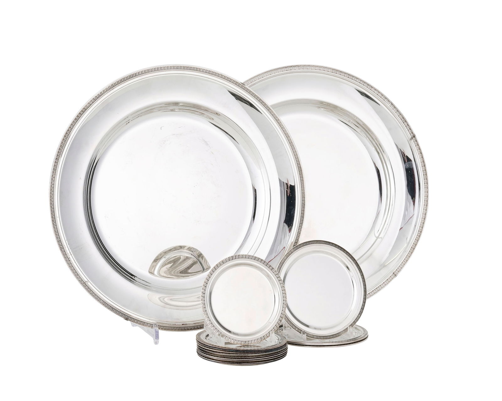 Ensemble de 13 dessous de bouteille (2 formats: 10+3) et 2 plats ronds de service en métal arge: Ensemble de 13 dessous de bouteille (2 formats: 10+3) et 2 plats ronds de service en métal argenté Christofle, à décor de feuilles d'eau, diam. 13, 15,5 et 40 cm Provenance: